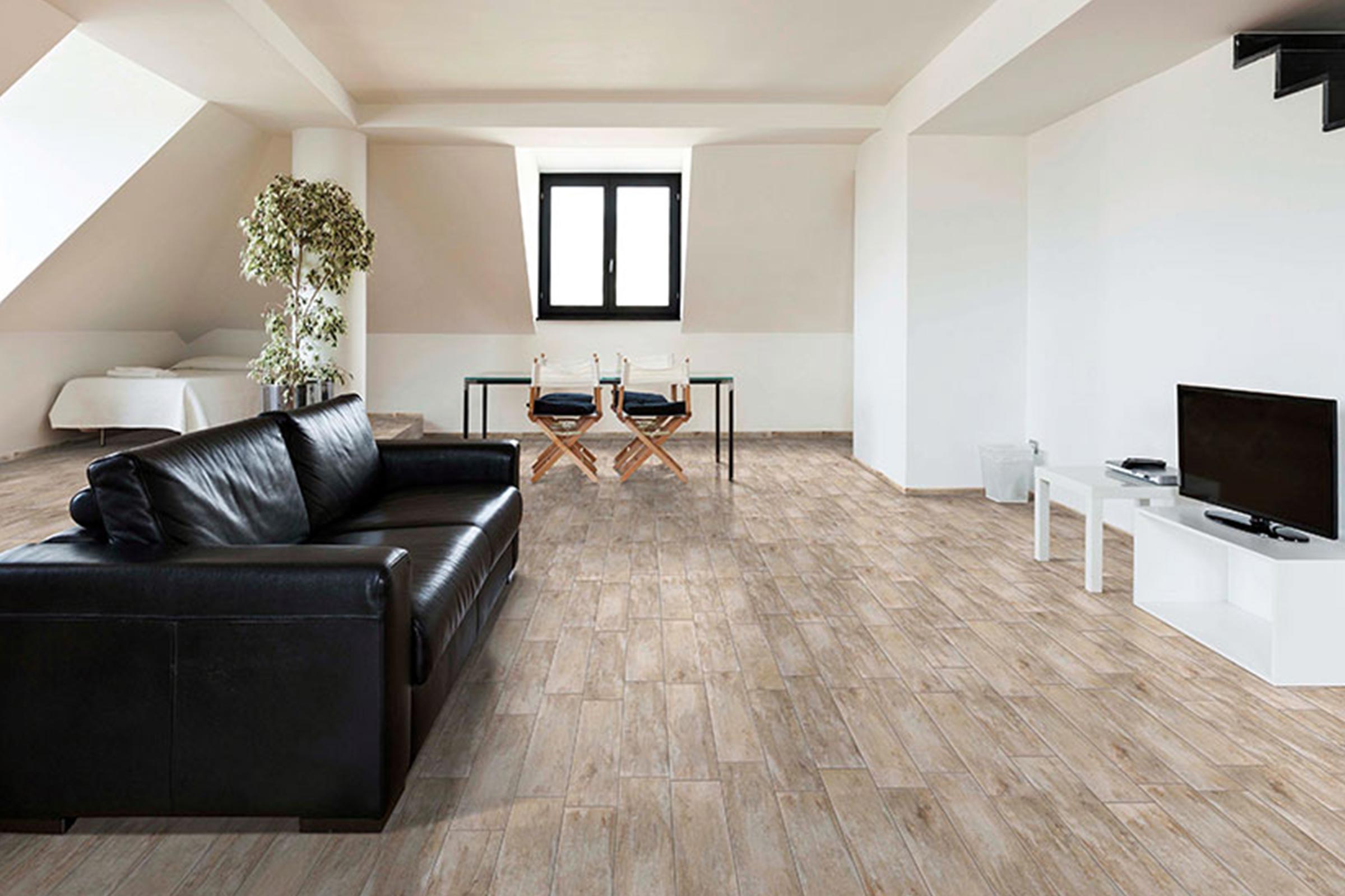 Living luminos cu gresie aspect lemn, canapea și televizor