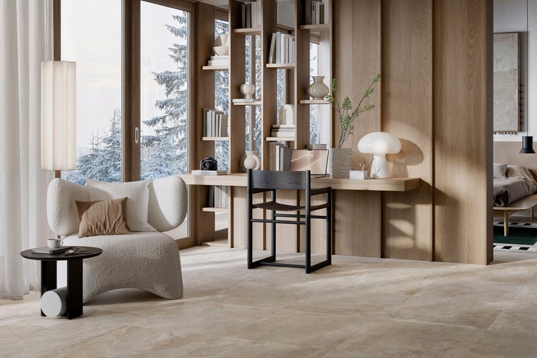 Birou luminos cu fotoliu, birou și bibliotecă în fața unei ferestre cu peisaj de iarnă