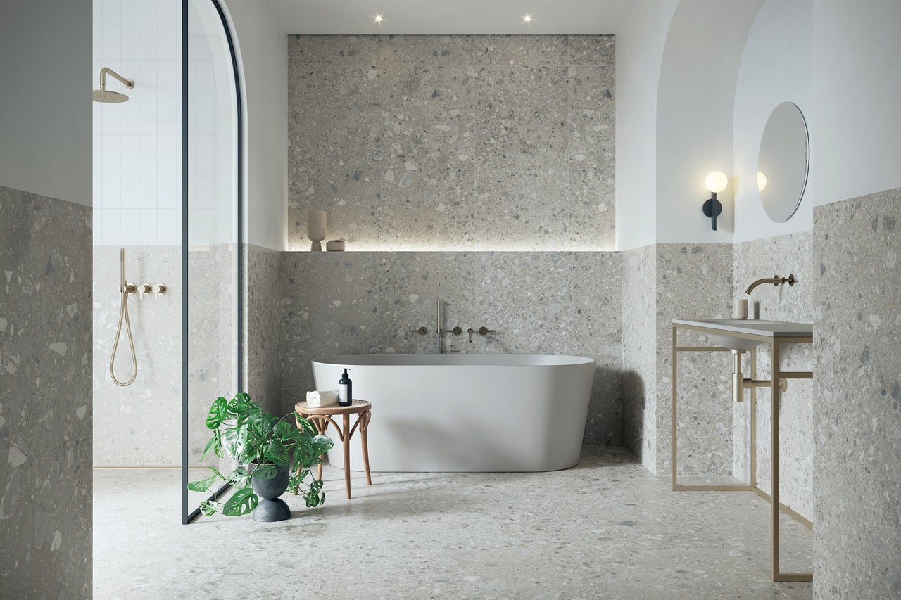 Baie modernă cu cadă, duș și chiuvetă cu aspect de terrazzo