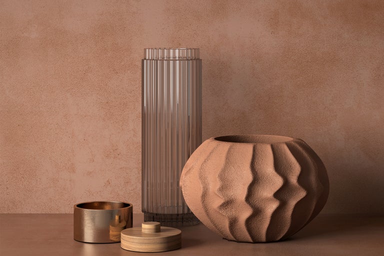 Aranjament decorativ cu o vază înaltă din sticlă, o vază sferică texturată și o cutie cu capac.