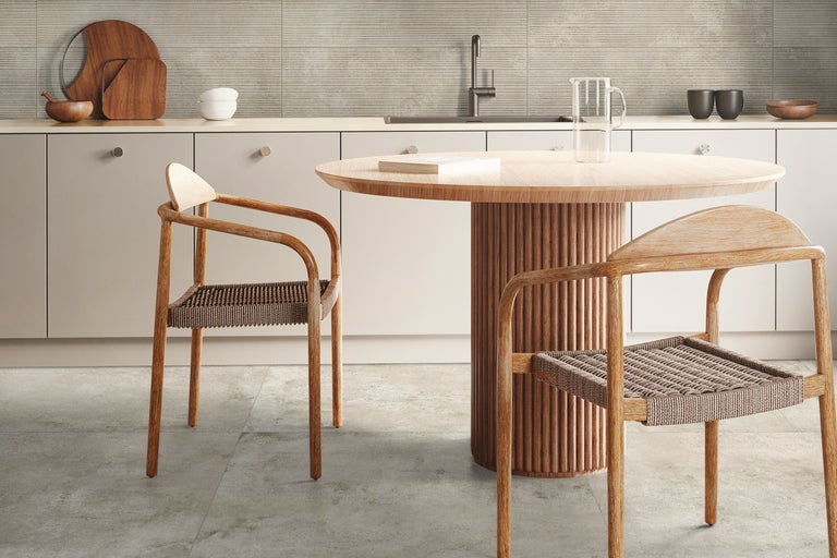 Bucătărie luminoasă cu masă și scaune din lemn, blat și perete cu faianță