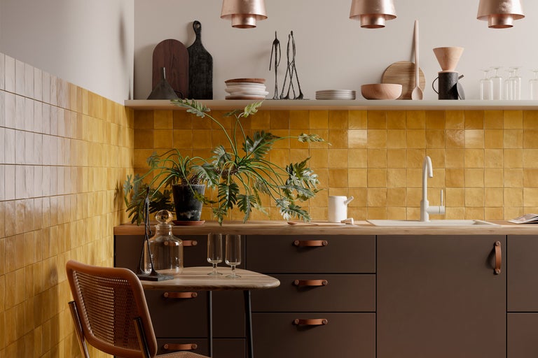 Bucătărie luminoasă cu dulapuri maro, faianță galbenă și elemente din lemn pentru o atmosferă caldă.