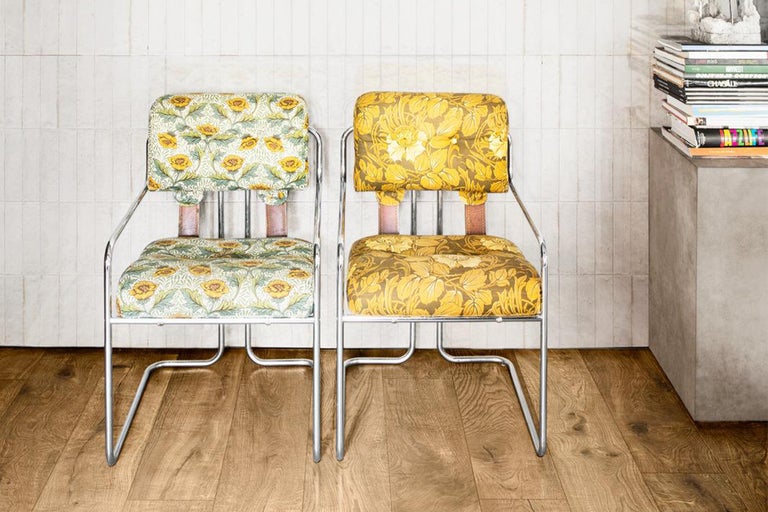 Două scaune cu modele florale și cadru metalic în fața unui perete