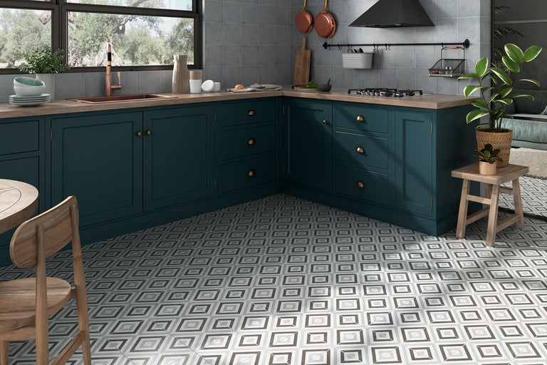 Imagine de bucătărie cu corpuri de bucătărie gri-albăstrui, blat de lucru din lemn și plăci de pardoseală cu model