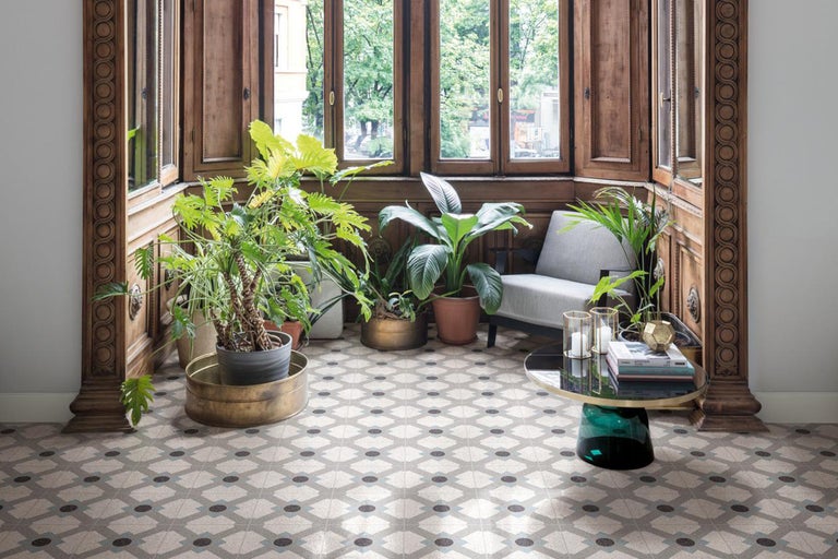 Cameră luminoasă cu podea cu gresie modelată, plante și elemente din lemn.