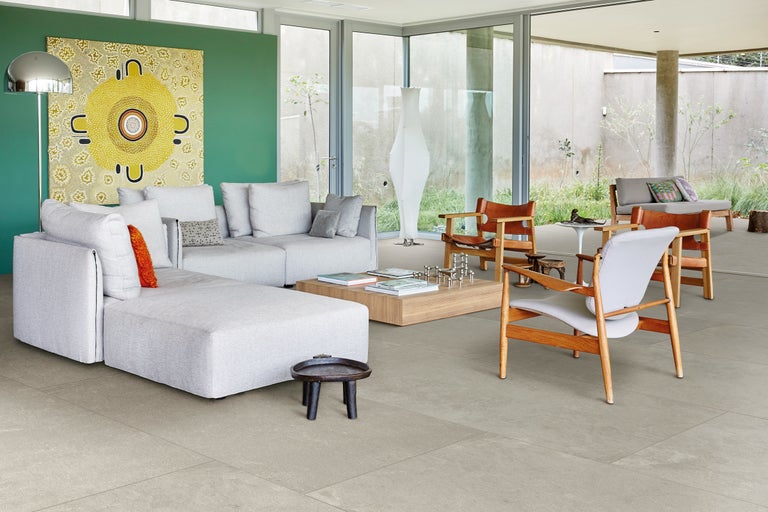 Cameră de zi cu canapea, scaune și podea cu gresie