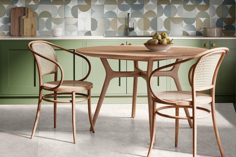 Bucătărie luminoasă cu masă rotundă din lemn și scaune cu șezuturi din ratan