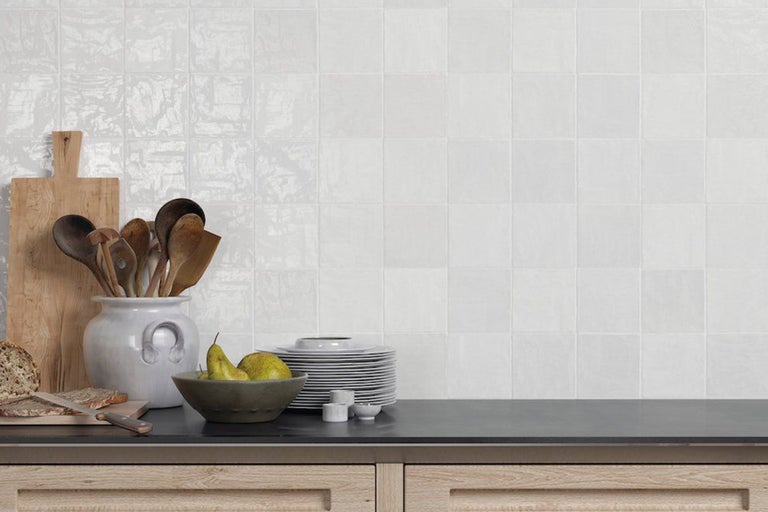 Scenă de bucătărie cu plăci albe, veselă și ustensile de bucătărie din lemn pe un blat