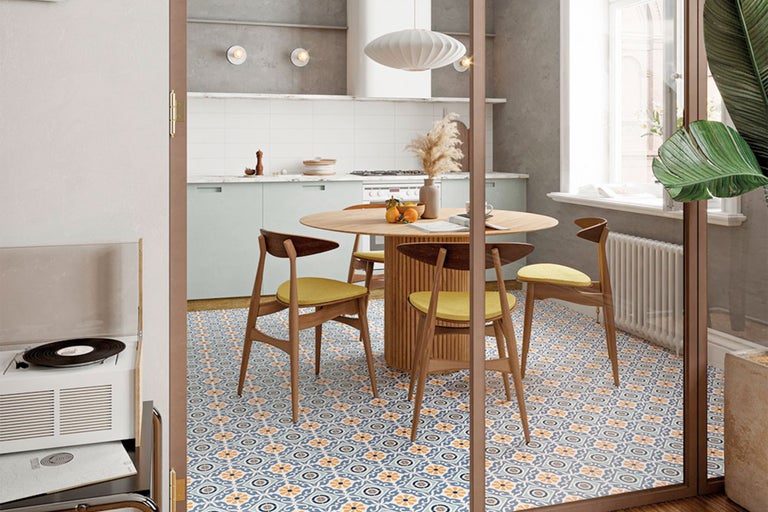 Sufragerie cu masă rotundă din lemn, scaune și gresie cu model.