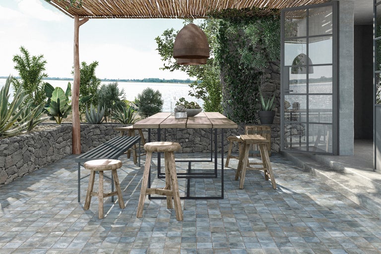 Scenă de terasă cu masă din lemn, scaune și bancă afară, cu vedere la lac