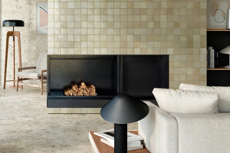 Living cu șemineu, pereți și podea cu gresie, canapea și lampă