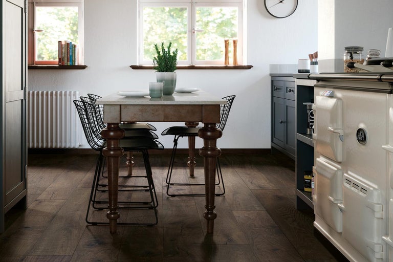 Bucătărie luminoasă cu masă de sufragerie, scaune, dulapuri de bucătărie și podea din lemn