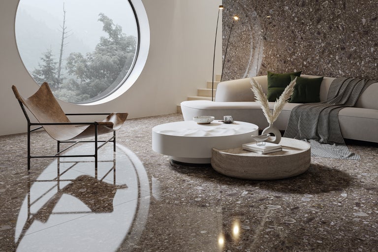 Living luminos cu fotoliu, canapea, măsuțe de cafea și fereastră rotundă mare