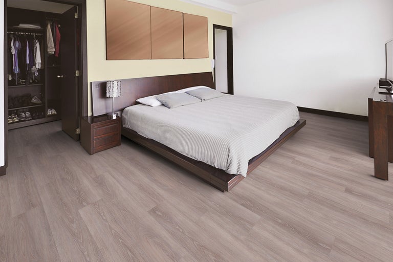 Dormitor luminos cu pat, dulap și podea laminată.