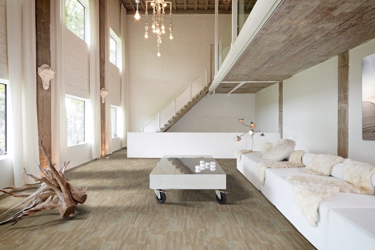 Cameră de zi luminoasă cu podea din lemn cu aspect de țiglă, canapea și masă