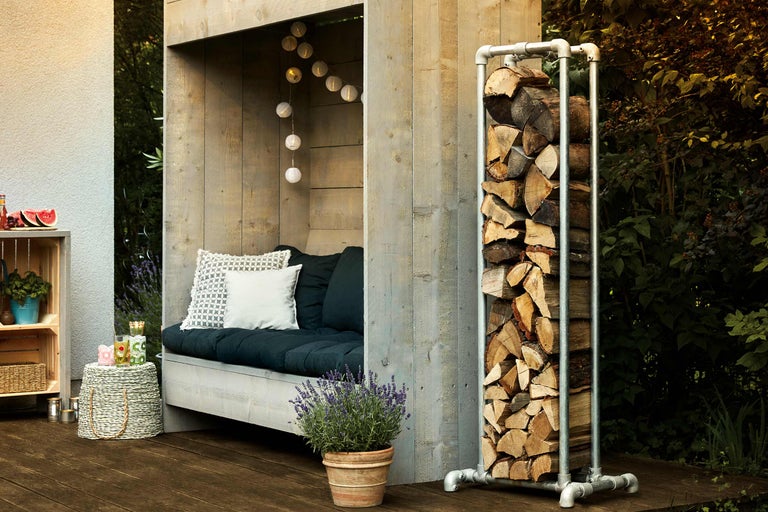 Spațiu exterior cu depozit de lemne, zonă de relaxare și decorațiuni pentru o atmosferă confortabilă