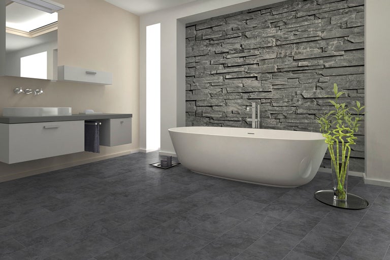 Baie modernă cu cadă freestanding, lavoar și perete de piatră