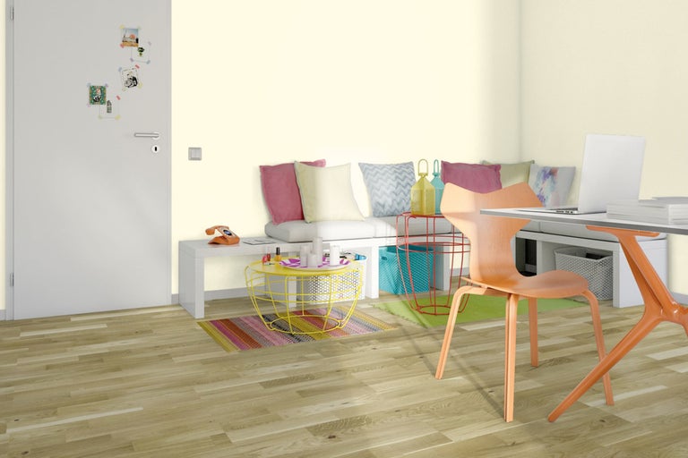 Cameră de zi luminoasă cu podea din lemn, zonă de relaxare cu perne, masă și scaun.