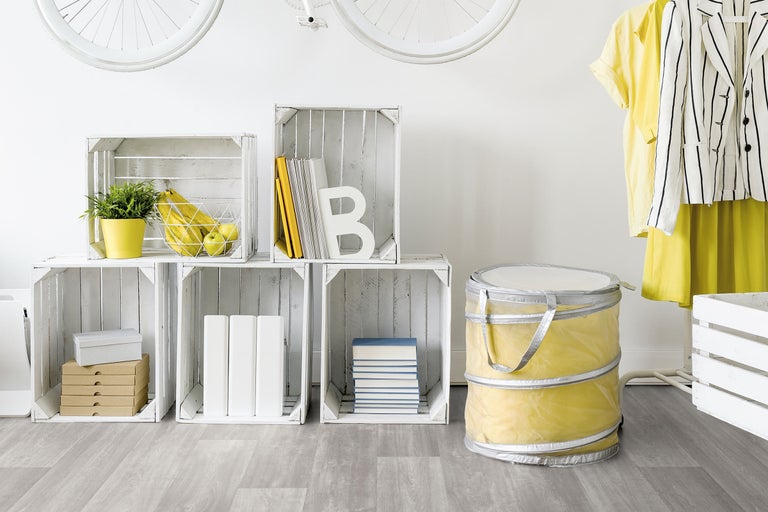 Interior luminos și primitor, cu rafturi din lăzi de lemn albe și textile