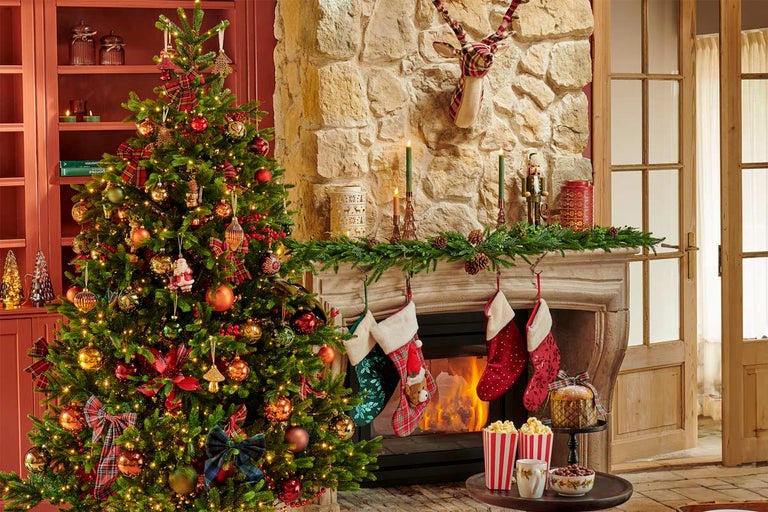 Cameră decorată festiv cu brad de Crăciun, șemineu și decorațiuni de Crăciun pentru o atmosferă confortabilă.