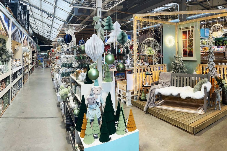 Interiorul unui magazin de bricolaj Hornbach cu decorațiuni de Crăciun și articole decorative pe rafturi și în vitrine.