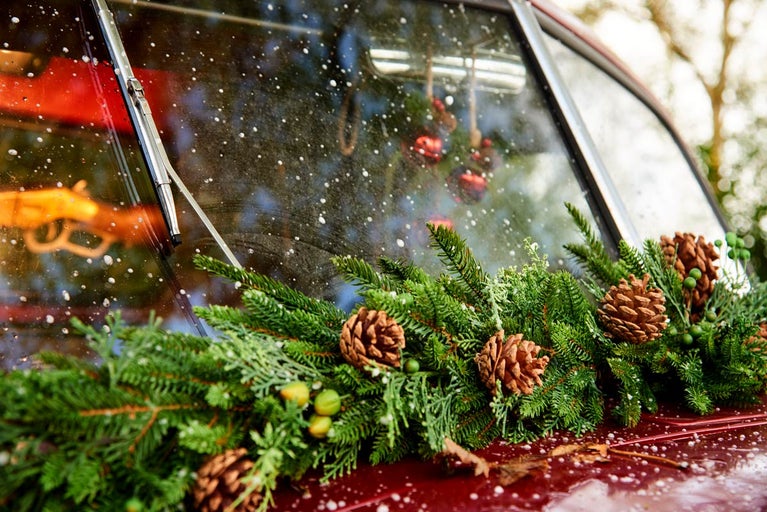 Mașină de epocă decorată cu ramuri de brad și conuri