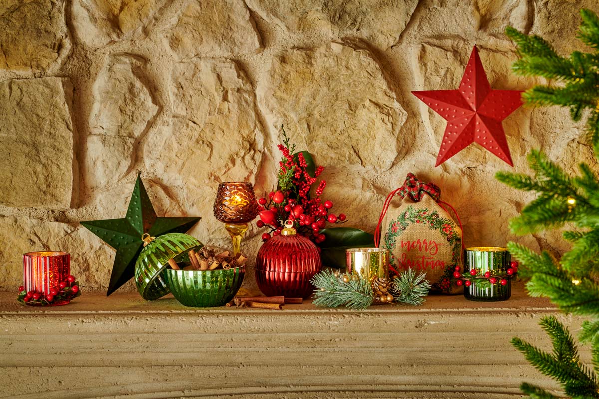 Șemineu decorativ cu decorațiuni de Crăciun, inclusiv suporturi pentru lumânări, stele și un sac de cadouri