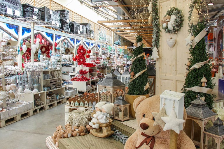 Spațiu de vânzare decorat cu articole de Crăciun, cum ar fi urși de pluș, ghirlande și pomi