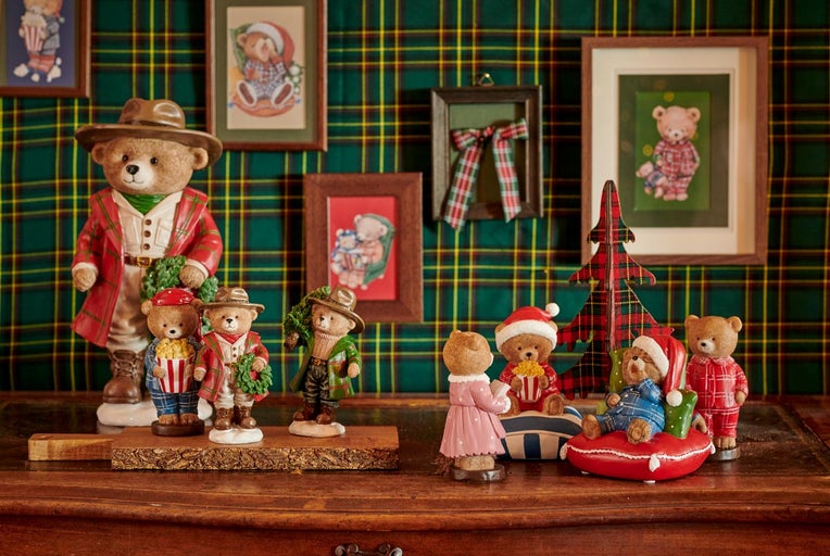 Figurine decorative cu ursuleți pe o suprafață de lemn, cu un fundal în carouri