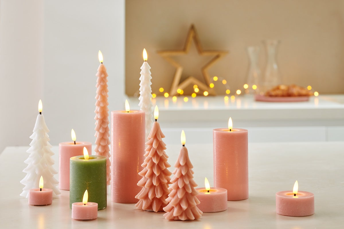 Aranjament decorativ de lumânări de diferite forme și dimensiuni.