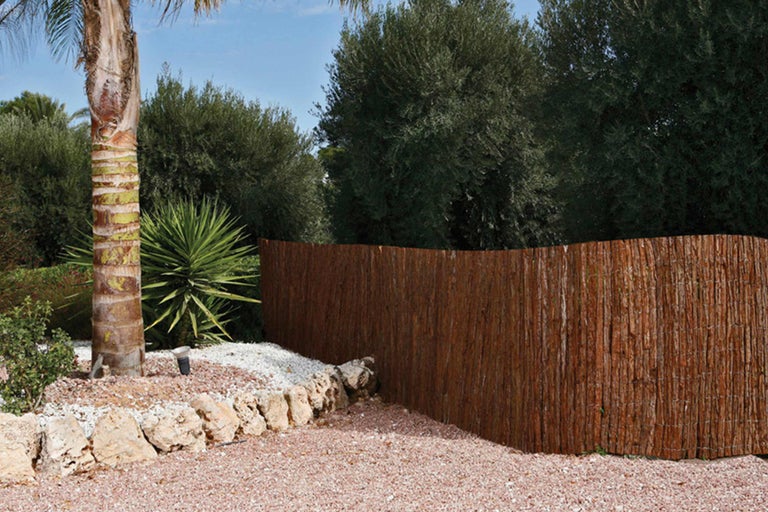 Scenă de grădină cu paravan de confidențialitate din materiale naturale, pietre și plante