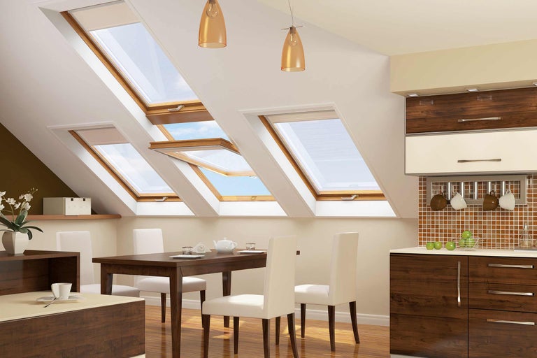 Apartament luminos la mansardă cu ferestre de mansardă, masă de sufragerie și chicinetă.