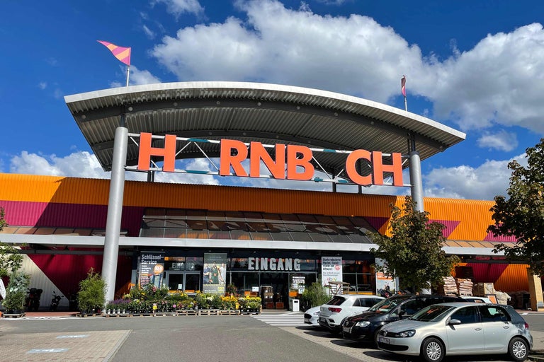 Vedere exterioară a unui magazin de bricolaj Hornbach cu parcare și intrare