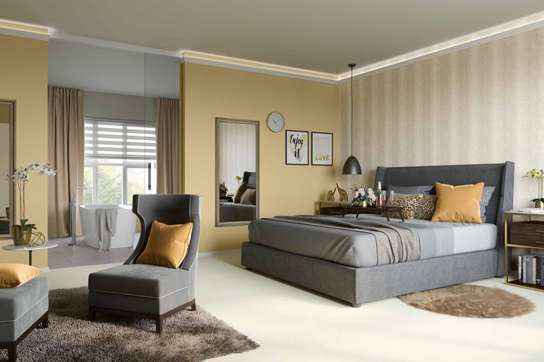 Dormitor luminos cu pat, fotoliu și zonă de baie