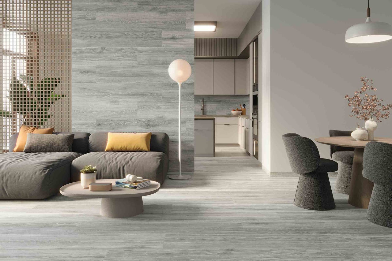 Living luminos cu gresie de podea cu aspect de lemn, canapea și zonă de luat masa