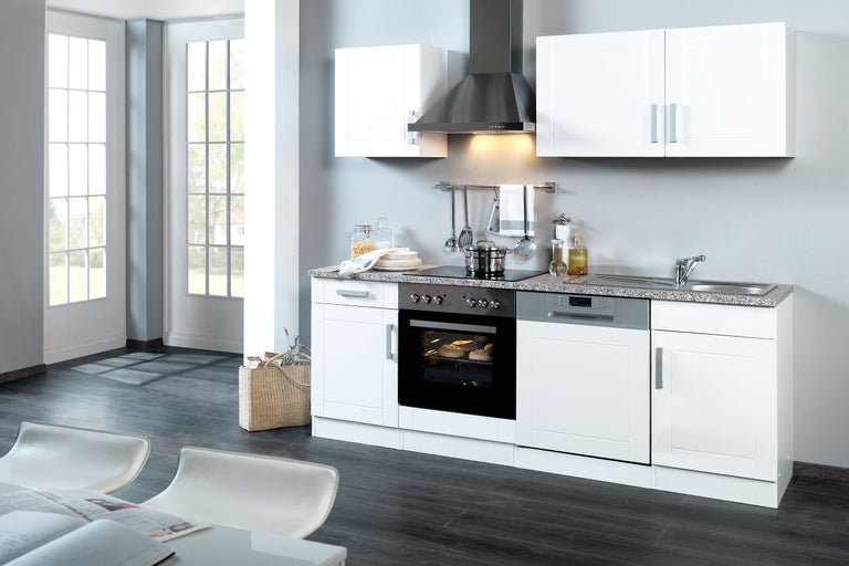 Bucătărie luminoasă cu dulapuri încorporate, chiuvetă, aragaz și hotă