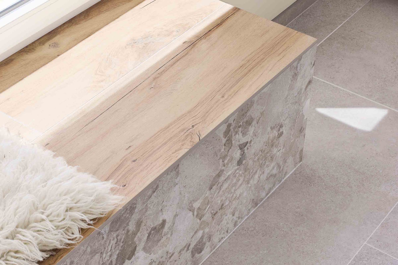 Masa de lemn deschis la culoare pe podea cu plăci de piatră