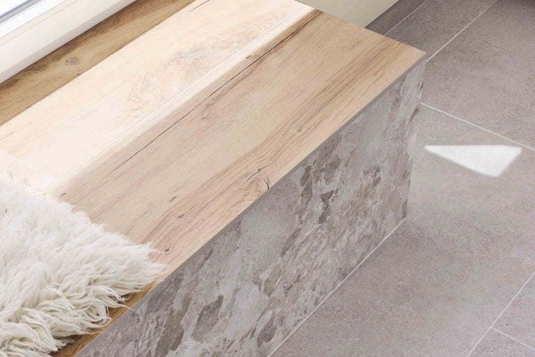 Masa de lemn deschis la culoare pe podea cu plăci de piatră