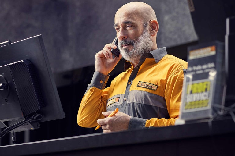 Un angajat Hornbach vorbește la telefon la biroul de service.