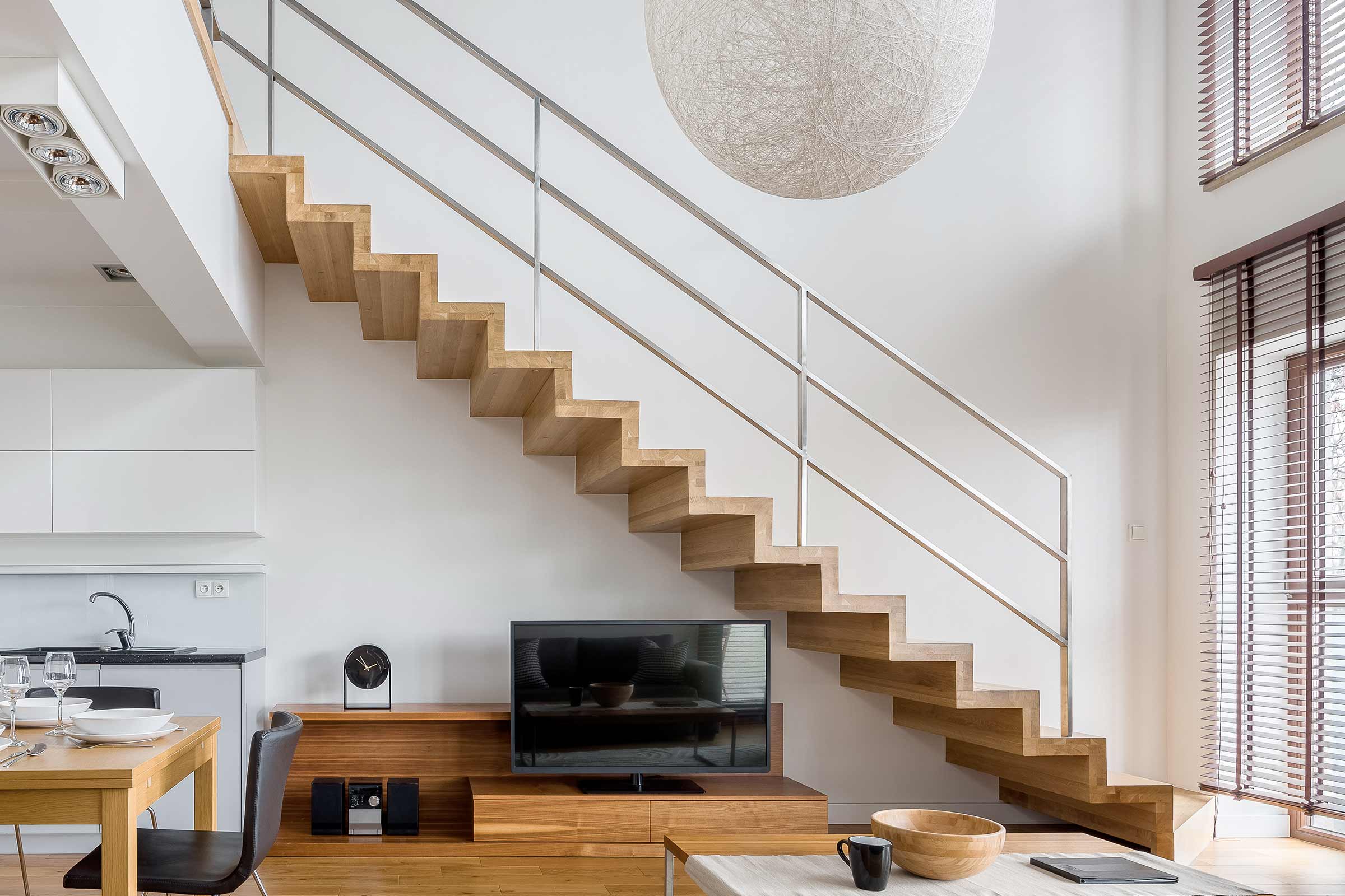 Living luminos cu scară din lemn, mobilier TV și decor minimalist