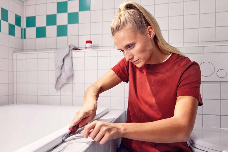 Curățarea unei plinte cu șpaclu și cârpă