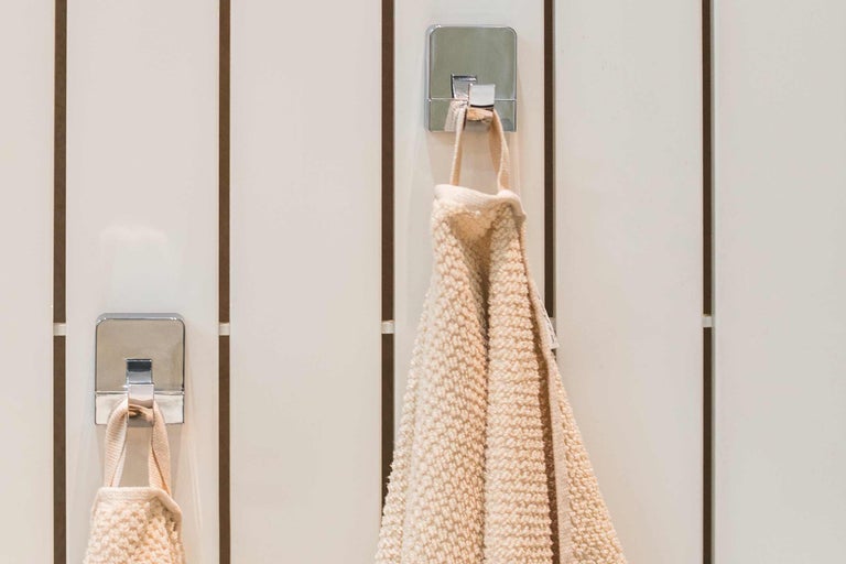 Prosoape pe cârlige cromate pe un perete