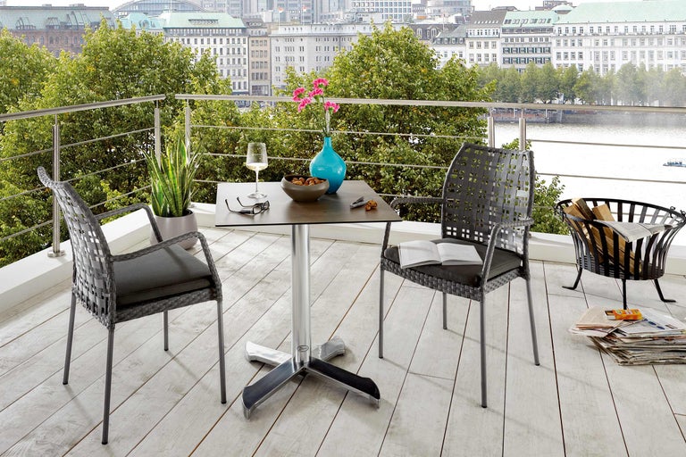 Scenă de balcon cu masă de grădină, scaune, decorațiuni și vedere la oraș