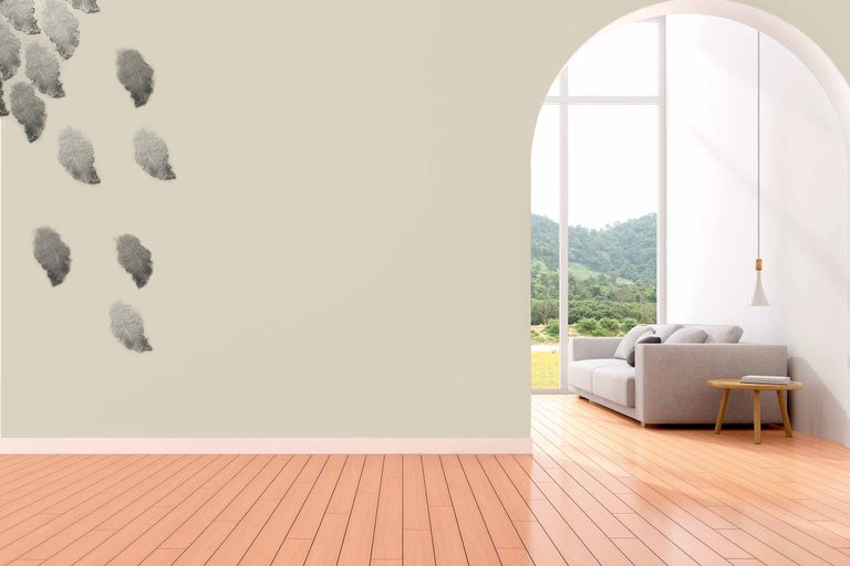 Cameră de zi cu autocolant de perete cu pene, canapea și podea din lemn