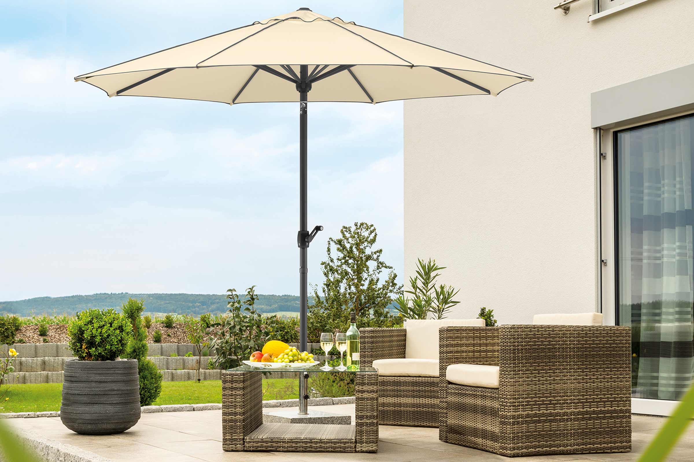 Scenă cu set de mobilier de grădină și umbrelă de soare pe o terasă