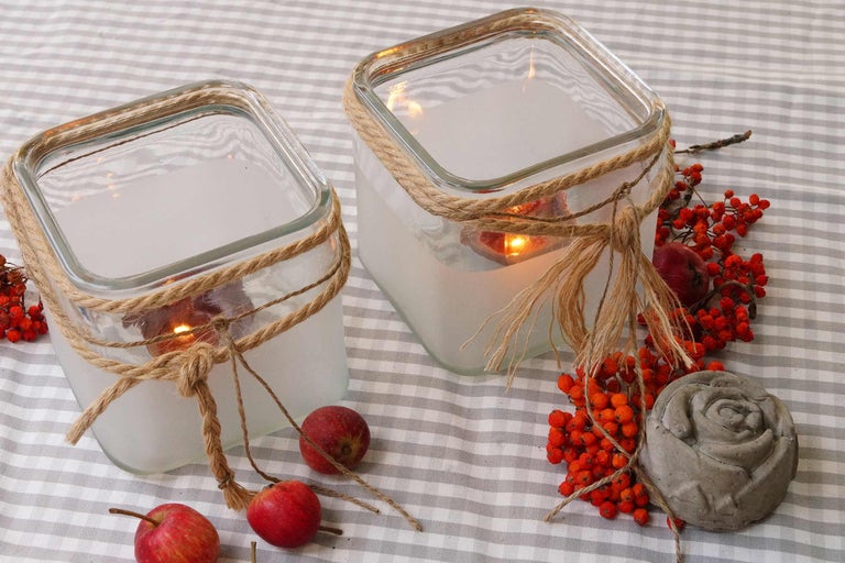 Lumânări decorative din sticlă cu sfoară de iută și decorațiuni de toamnă pe fața de masă