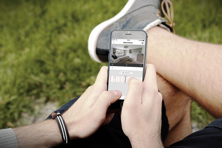 O persoană se uită la înregistrarea unei camere de securitate pe un smartphone.