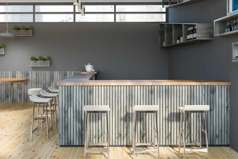 Fotografie de interior a unui bar cu elemente din lemn și scaune de bar