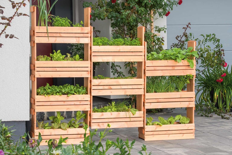 Trei rafturi din lemn pentru ierburi aromatice cu diverse ierburi pe o terasă