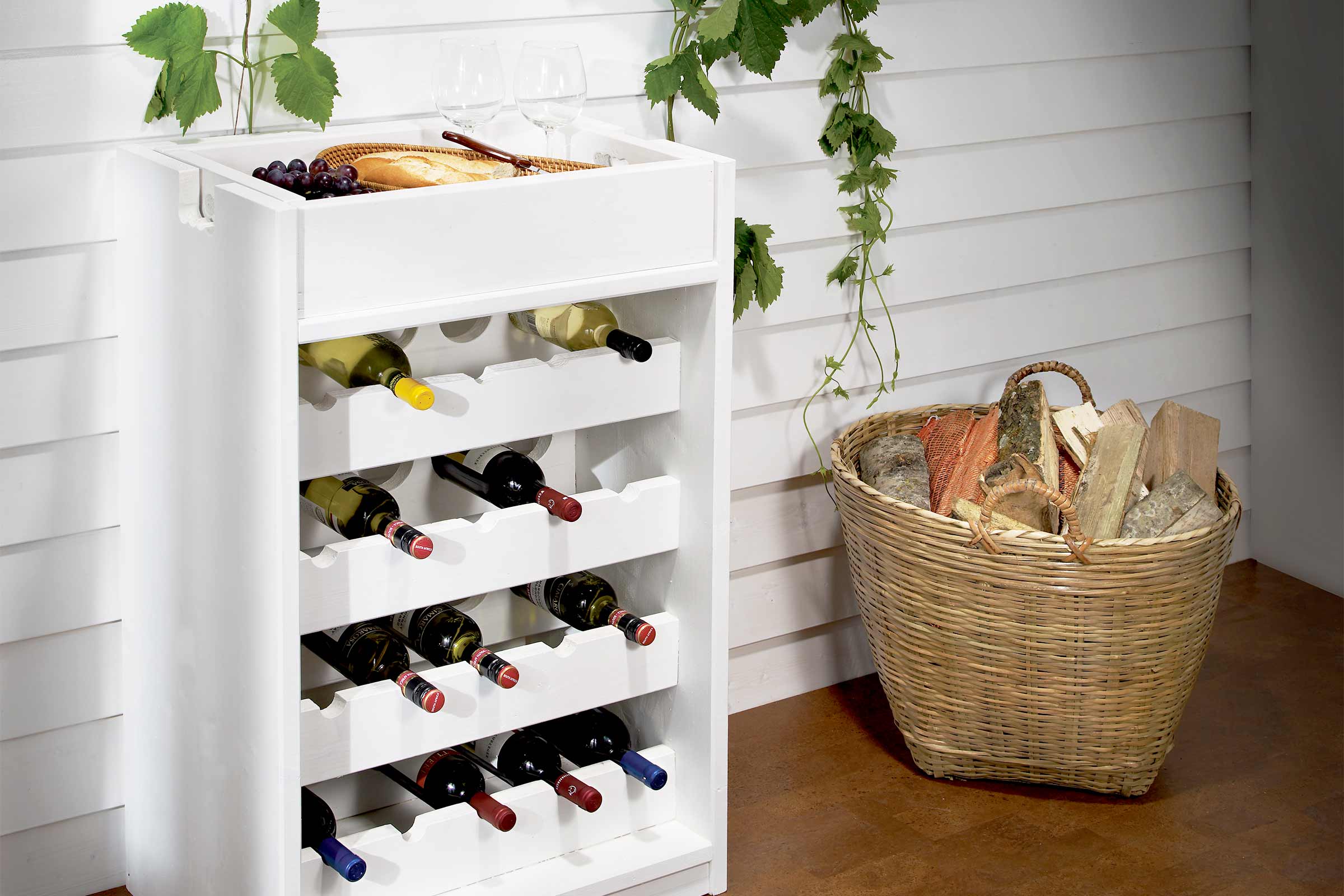Raft de vinuri din lemn cu sticle de vin umplute, pâine, struguri și coș de lemne